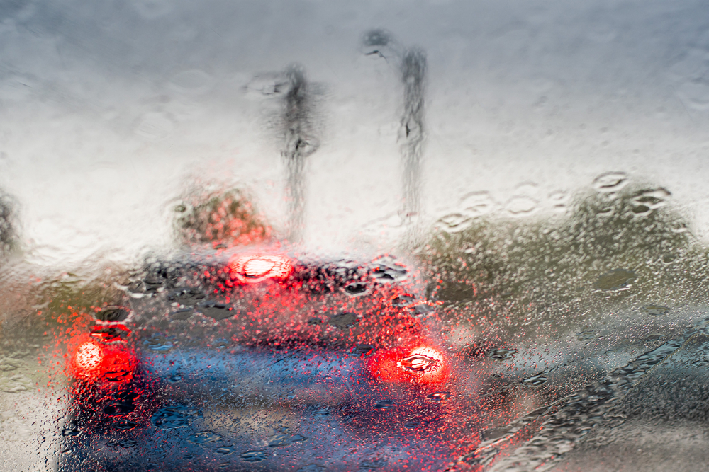 An obscured view of a traffic driving in heavy rain.